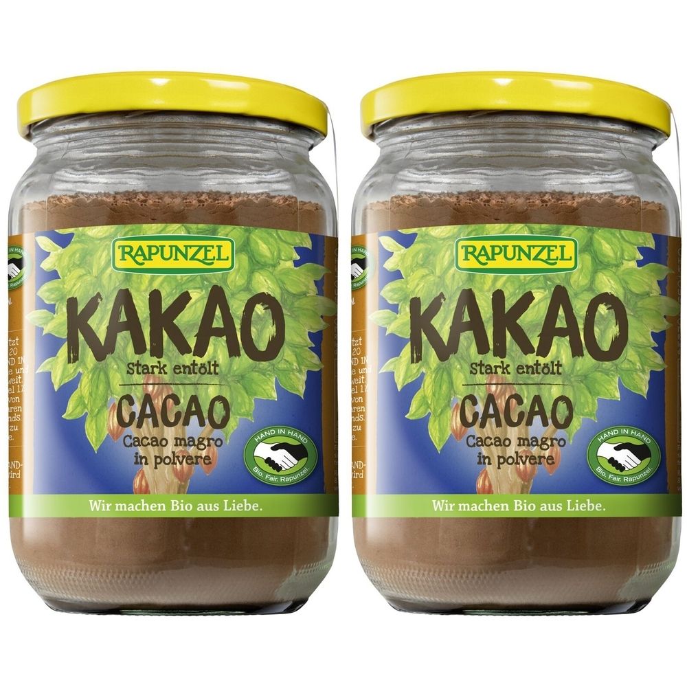 Zwei Gläser RAPUNZEL Kakaopulver. Aufschrift: KAKAO, stark entölt, CACAO, Cacao magro in polvere. Gelber Deckel, braunes Pulver.