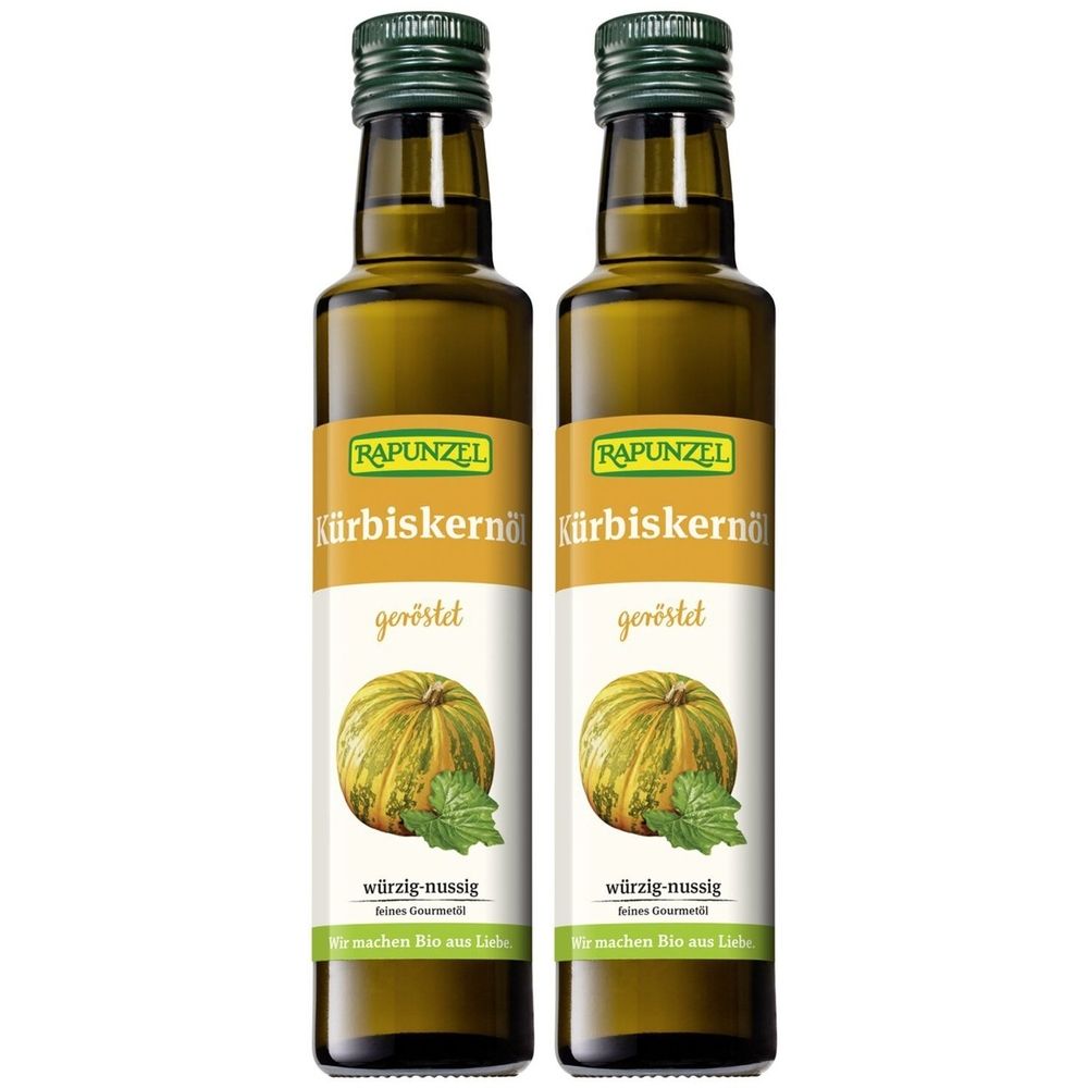 Zwei Flaschen Kürbiskernöl mit Etiketten. Aufschrift: RAPUNZEL, Kürbiskernöl, geröstet, würzig-nussig. Abbildung einer Kürbis.