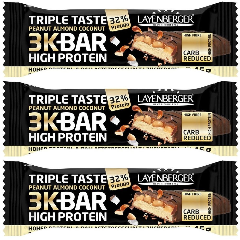 Drei Proteinriegel mit Erdnuss, Mandel und Kokos. Schwarze Verpackung mit Produktnamen und Logo. Enthält 32% Protein, High Fibre und Carb Reduced.