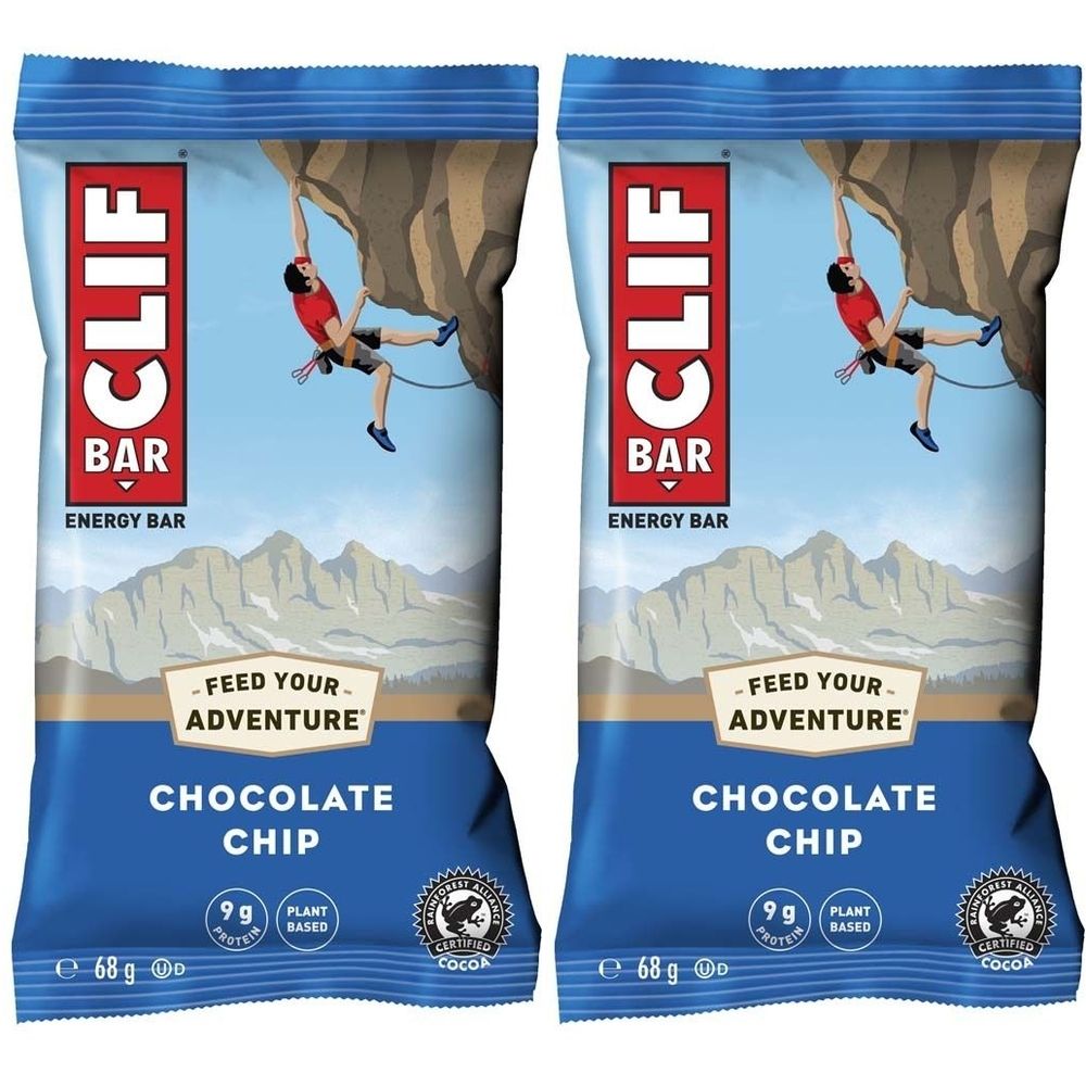 Zwei blaue CLIF BAR Energieriegel-Verpackungen. Aufdruck: CLIF BAR, Schokoladenstückchen, 9g Protein, Kakao-Zertifizierung.