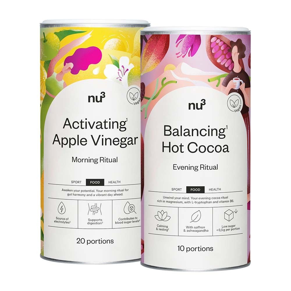 Zwei zylindrische Dosen. Eine mit "Activatin Apple Vinegar", die andere mit "Balancing Hot Cocoa". Beide mit Logo "nu3" und veganem Siegel.