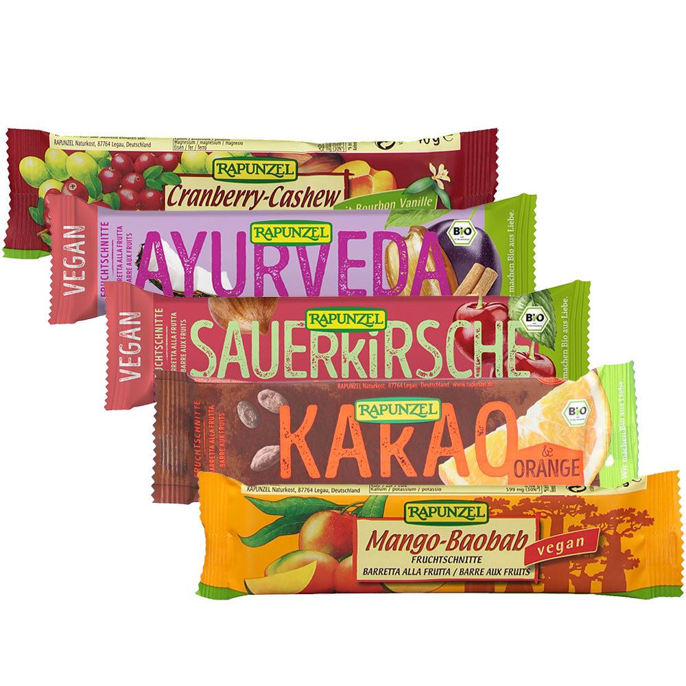 Fünf Fruchtschnitte-Riegel, verschiedene Geschmacksrichtungen. Aufschrift: RAPUNZEL, Cranberry-Cashew, Ayurveda, Sauerkirsche, Kakao-Orange, Mango-Baobab.