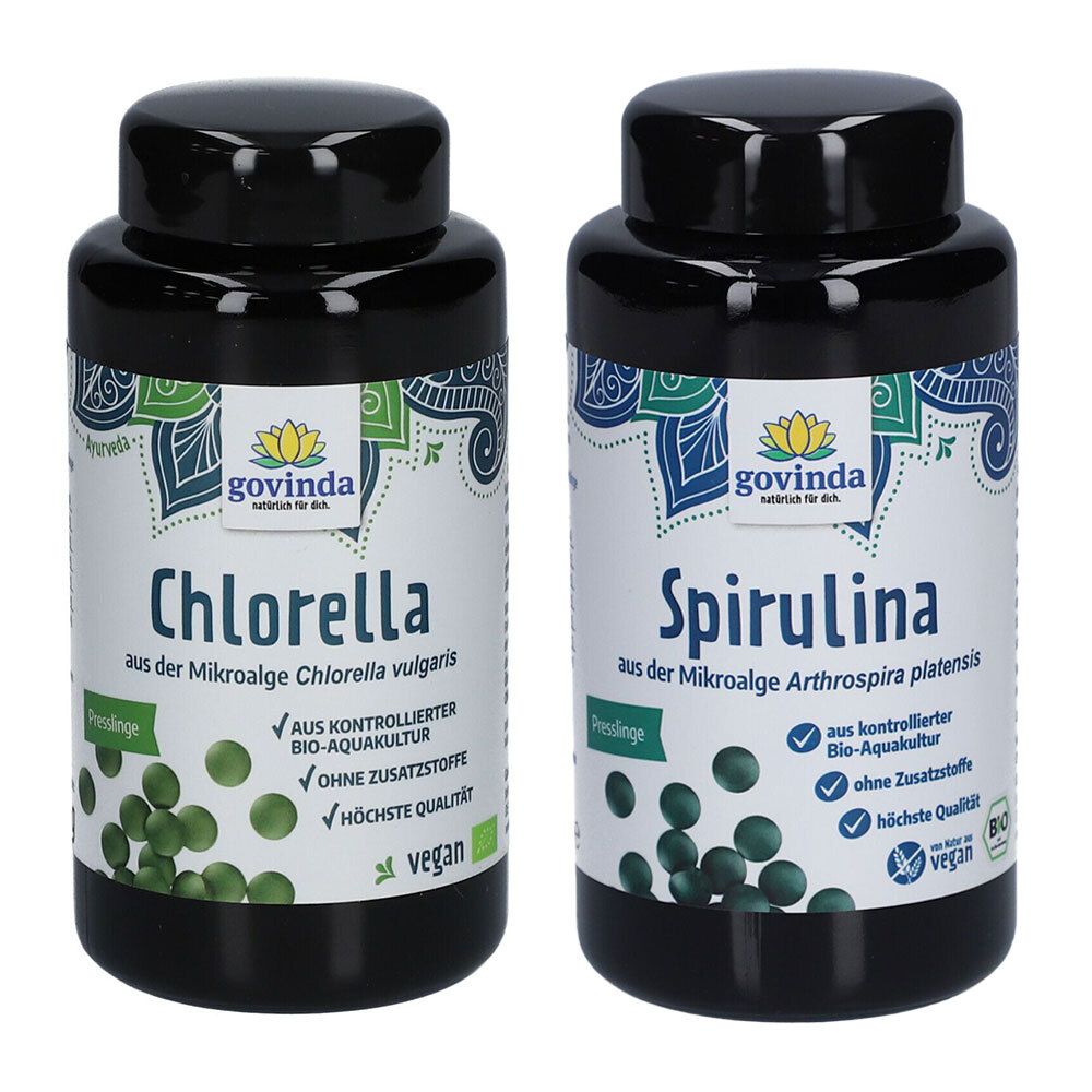 Zwei schwarze Flaschen mit Etiketten. Aufschrift: Govinda Chlorella und Spirulina. Vegan-Siegel. Grüne Tabletten sind abgebildet.