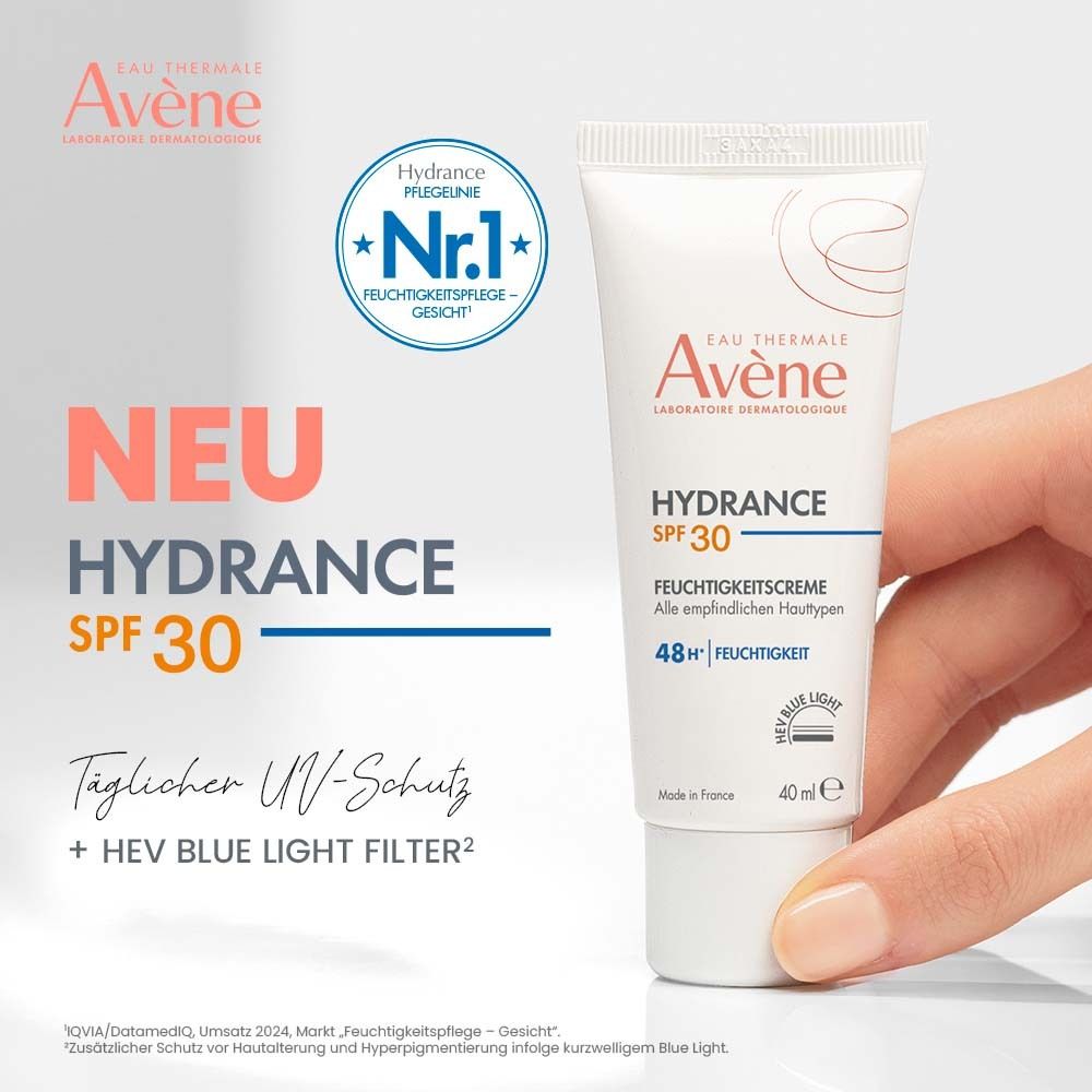 Hand hält Avène Hydrance Feuchtigkeitscreme SPF 30. Text: Täglicher UV-Schutz + HEV Blue Light Filter. Tube weiß mit roter Schrift, 40 ml.