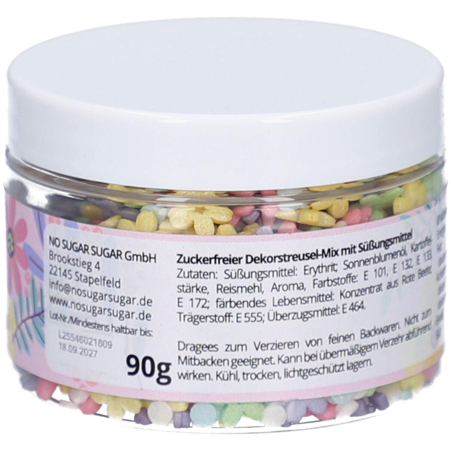 Klare Dose mit bunten, blütenförmigen Streuseln. Aufkleber mit Zutaten, Marke und Gewicht: 90g. Deckel weiß.