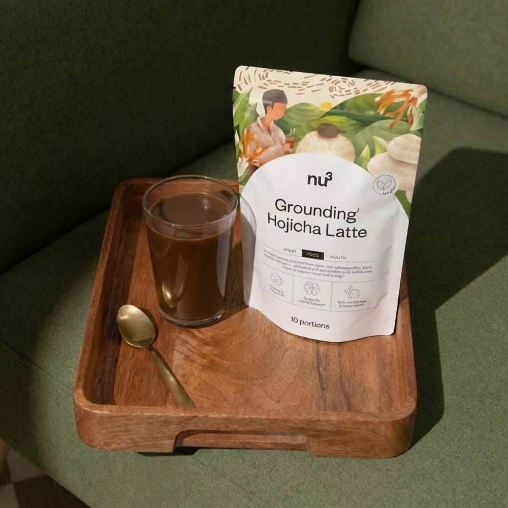 Holztablett mit Glas Getränk, Produktverpackung von nu3 Grounding Hojicha Latte und goldener Löffel.