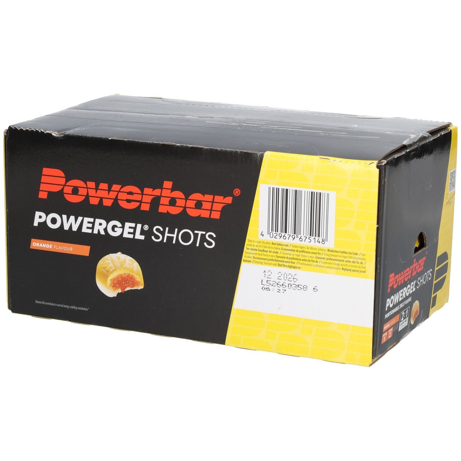 Schwarzer Karton mit Powerbar Powergel Shots. Orangefarbene Geleestücke sind abgebildet. Text: Orange Flavor.
