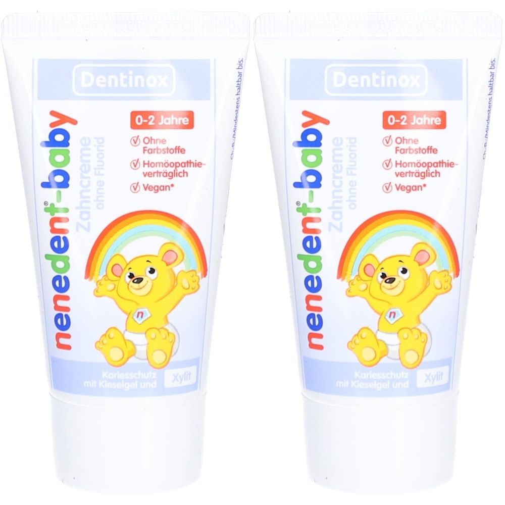 Zwei Tuben nenedent-baby Zahncreme. Weiße Tuben mit blauem und rotem Aufdruck. Aufdruck: Bär, Regenbogen, ohne Fluorid, 0-2 Jahre.