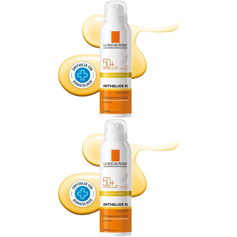 Zwei weiße Sprühflaschen mit orangefarbenen Akzenten. Aufschrift: Anthelios XL, 50+, empfohlen von Dermatologen. Gelbe Flüssigkeit im Hintergrund.