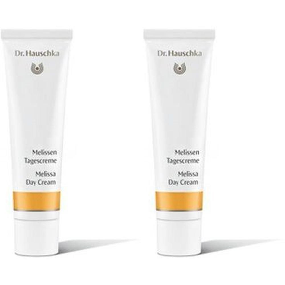 Zwei weiße Tuben Dr. Hauschka Melissen Tagescreme mit goldfarbenem Band.