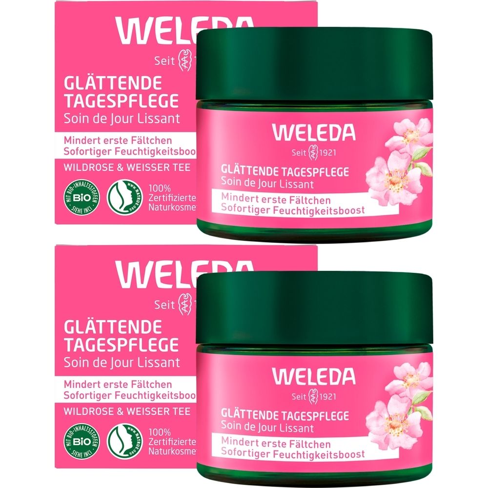 Mehrere Tiegel Tagespflege mit rosa Etikett und grünen Deckeln. Aufschrift: Weleda, Glättende Tagespflege, Wildrose & Weißer Tee.