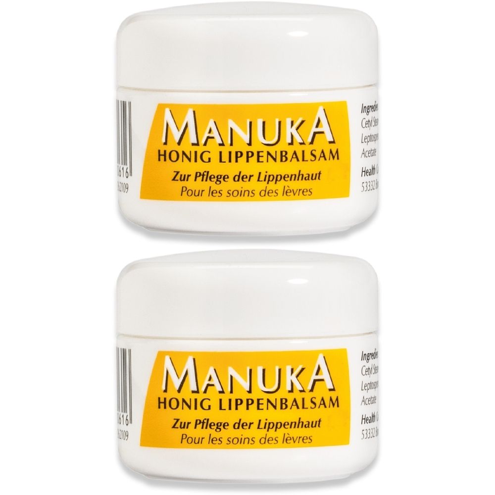 Zwei weiße Tiegel mit gelbem Etikett. Aufschrift: MANUKA HONIG LIPPENBALSAM. Text in Deutsch und Französisch.