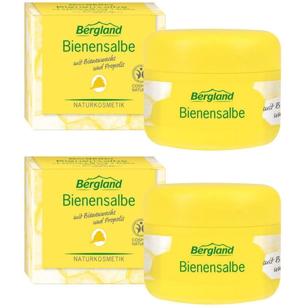 Zwei gelbe Tiegel und zwei Kartons mit der Aufschrift "Bergland Bienensalbe". Auf den Tiegeln und Kartons ist das Logo "Cosmos Natural" zu sehen.