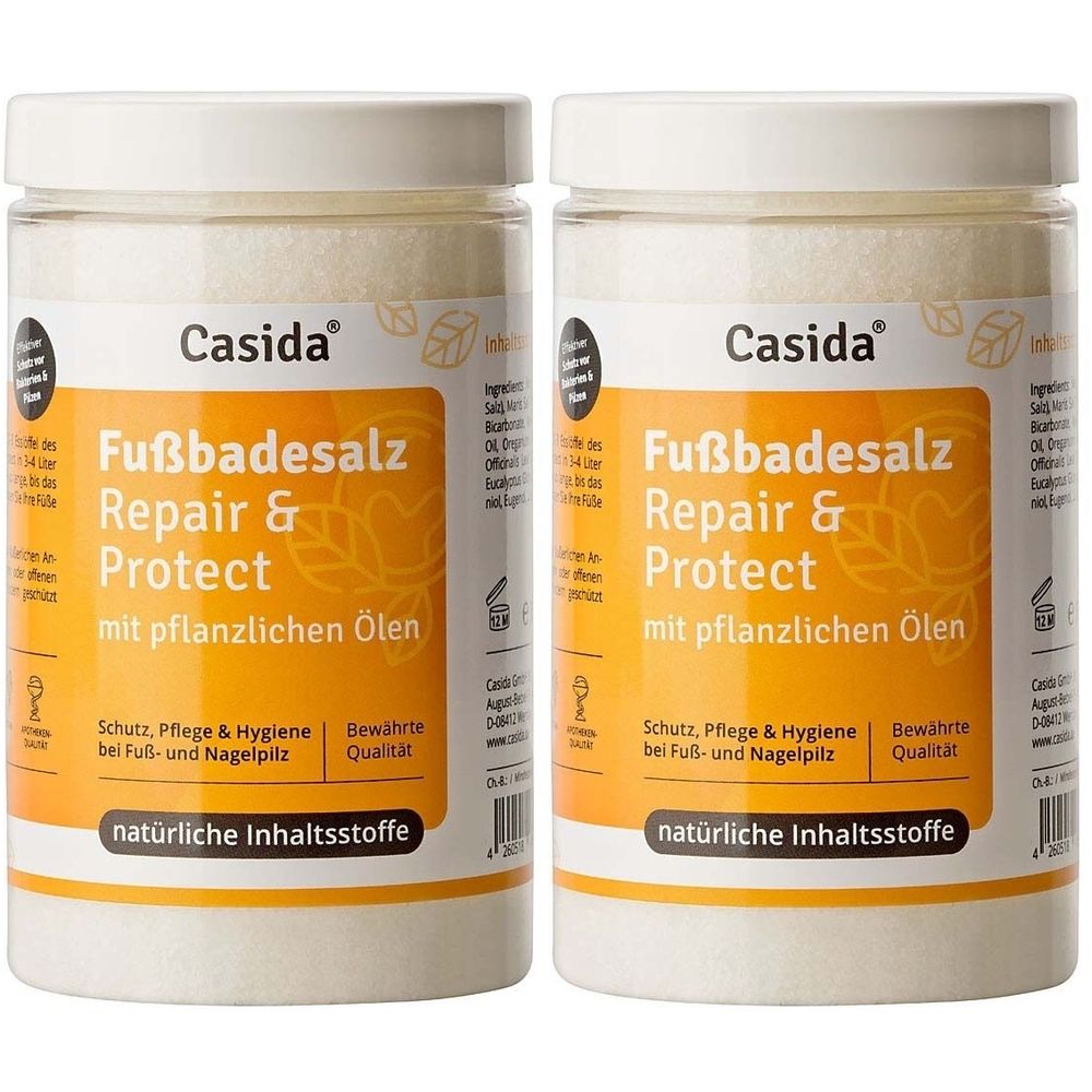 Zwei transparente Behälter mit weißem Fußbadesalz. Auf den Etiketten steht "Casida Fußbadesalz Repair & Protect".