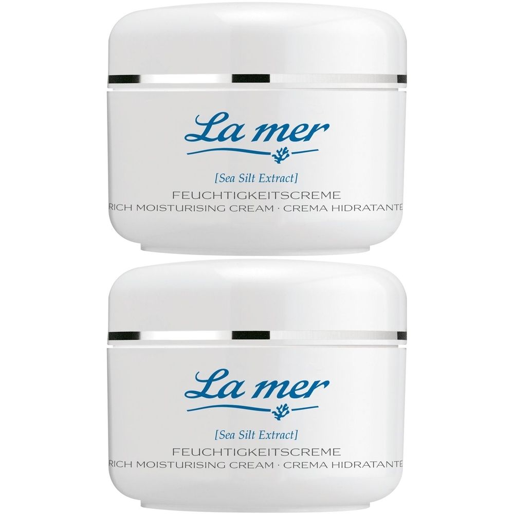 Zwei weiße Tiegel mit Deckel. Aufschrift: La mer, Feuchtigkeitscreme. Silberner Zierstreifen.