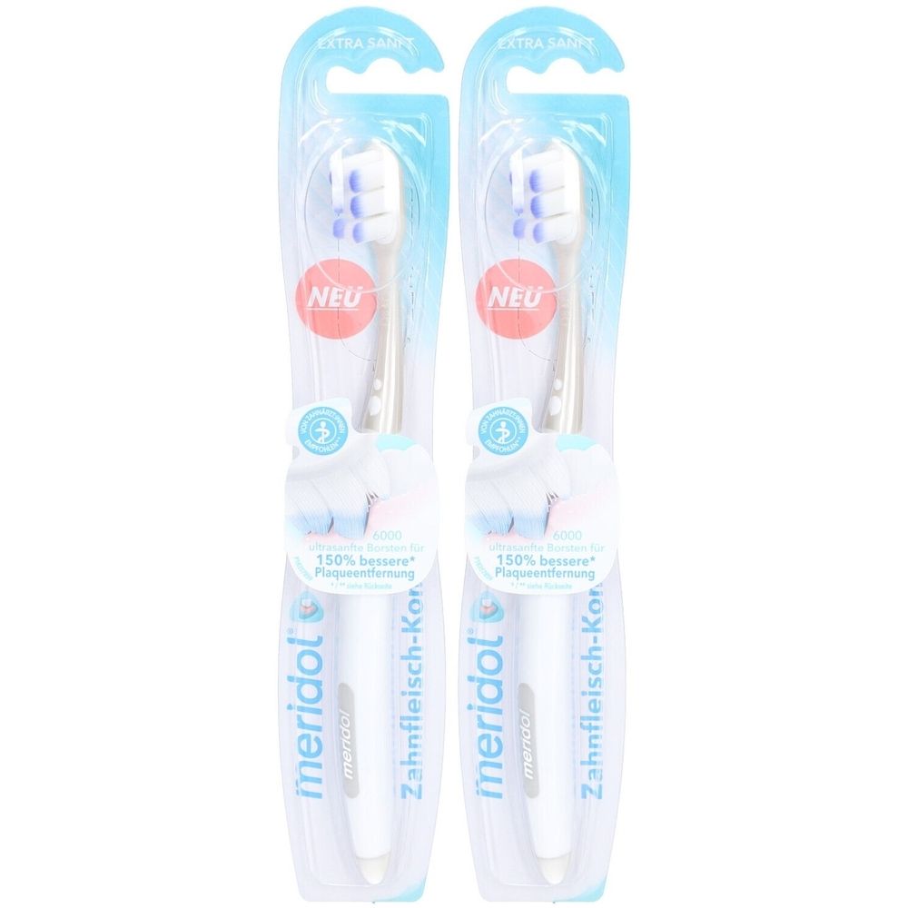 Zwei Zahnbürsten in Blisterverpackung. Weiße Griffe, blaue Borsten, lila Akzente. Aufschrift: meridol, EXTRA SANFT, NEU.