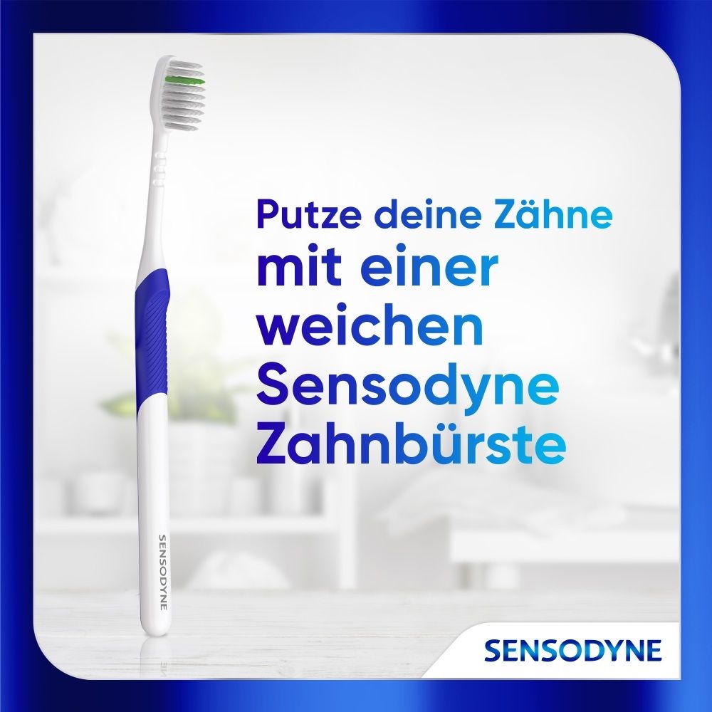 Eine weiße Sensodyne Zahnbürste mit blauem Griff und grünen Borsten.