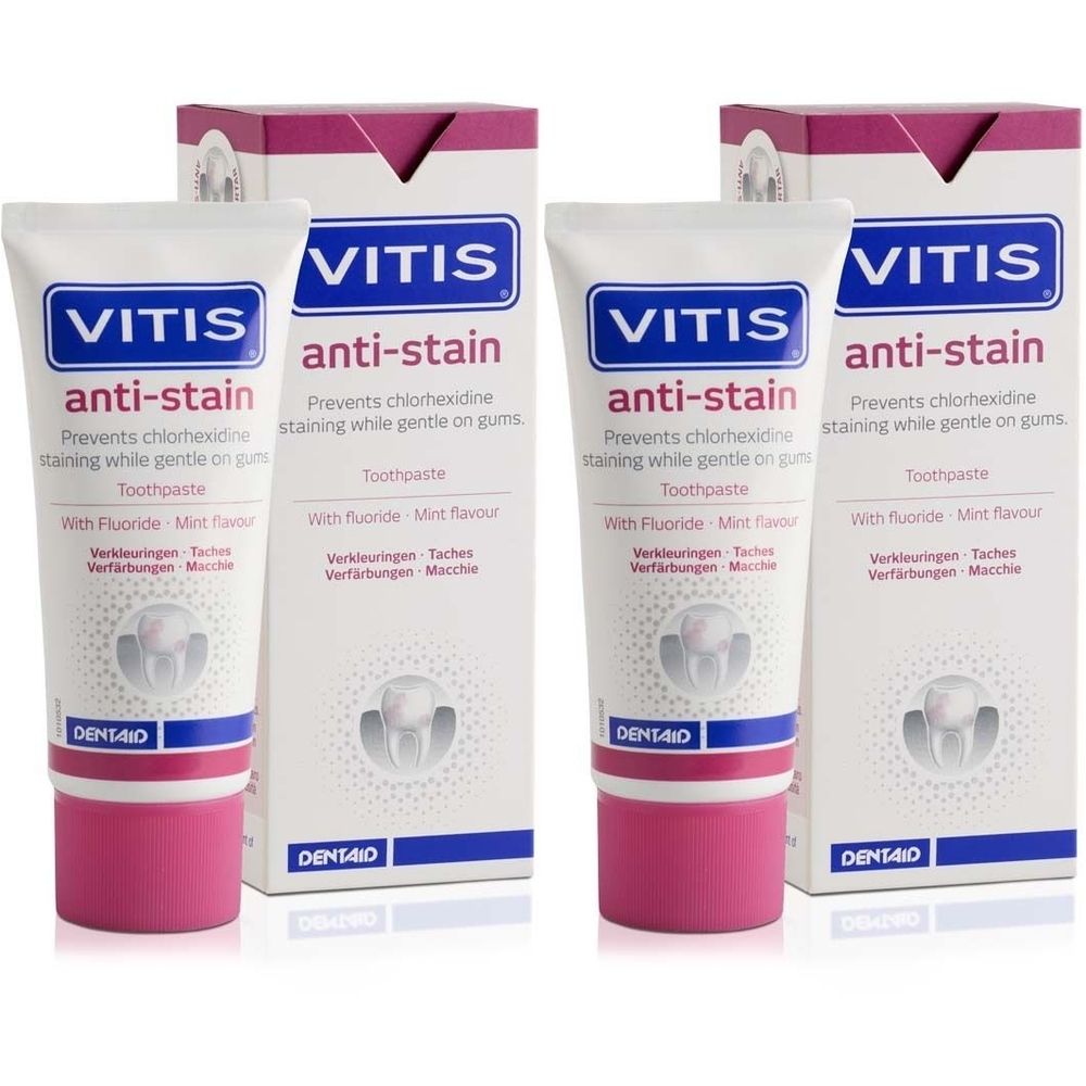 Zwei Tuben und zwei Kartons VITIS anti-stain Zahnpasta. Weiße Tuben mit pinkfarbenem Verschluss und blauer Schrift. Kartons mit Produktnamen.