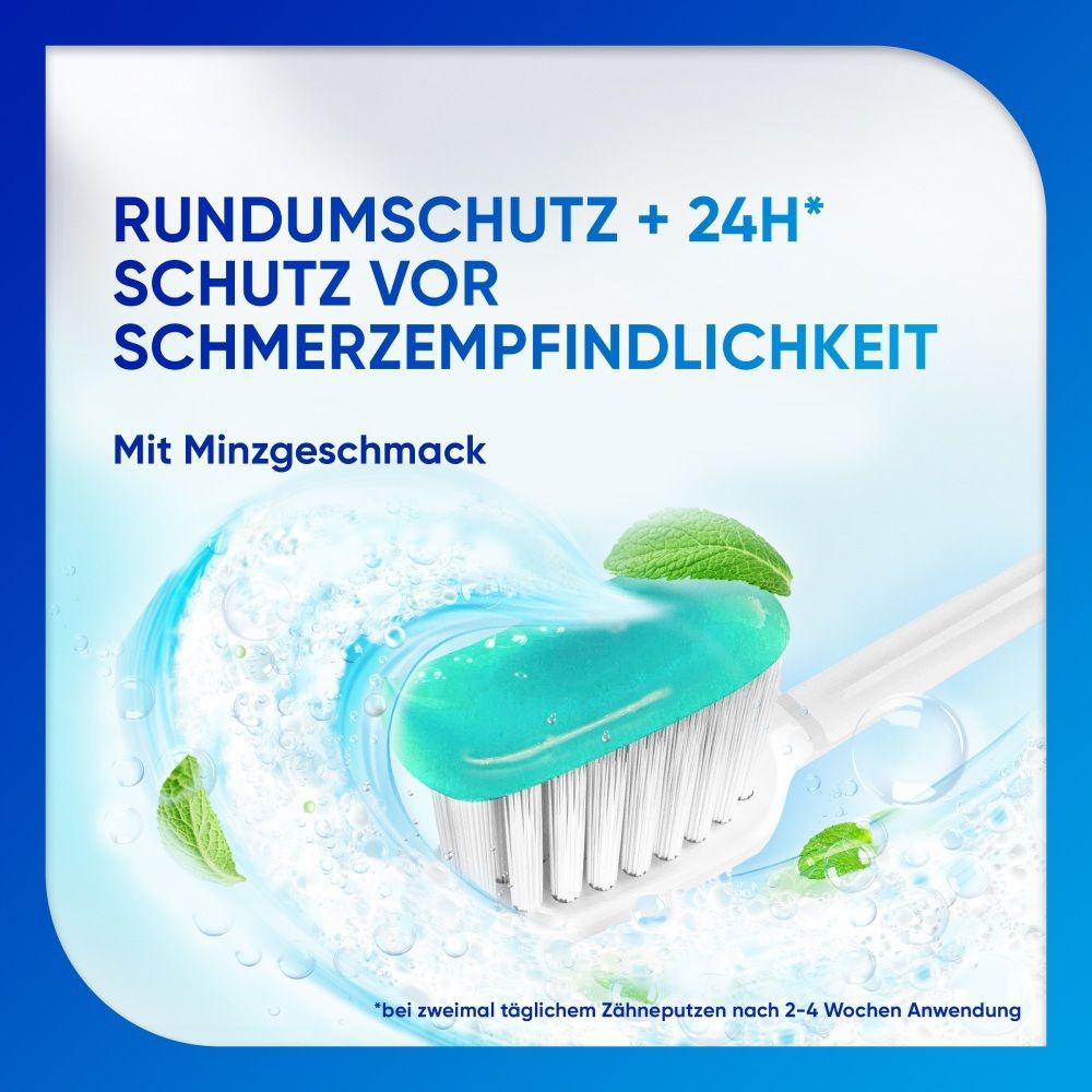 Zahnpasta mit Minzgeschmack auf einer Zahnbürste, umgeben von Wasserspritzern und Minzblättern.