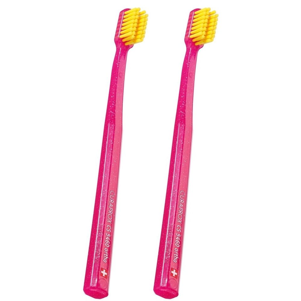 Zwei pinke Zahnbürsten mit gelben Borsten. Auf dem Griff steht CURAPROX CS 5460 ortho.