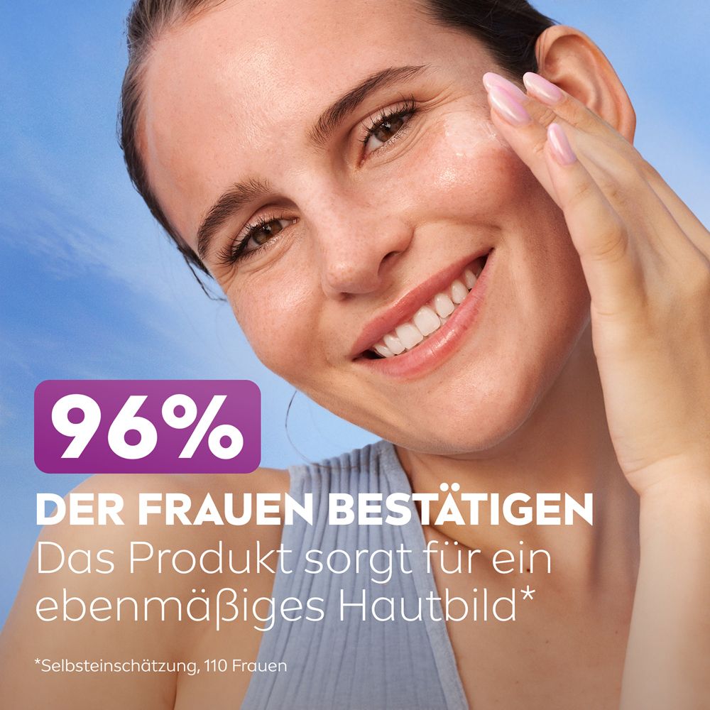 Frau berührt ihr Gesicht. 96% bestätigen ein ebenmäßiges Hautbild. Produkt von NIVEA.