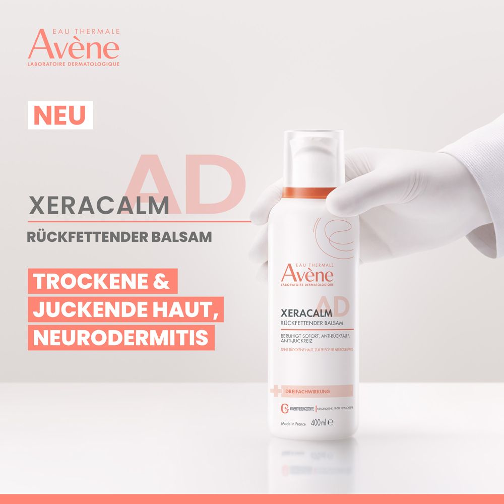 Weißes Produkt mit orangefarbenem Etikett, XeraCalm A.D Rückfettender Balsam. Hand mit Handschuh hält das Produkt.