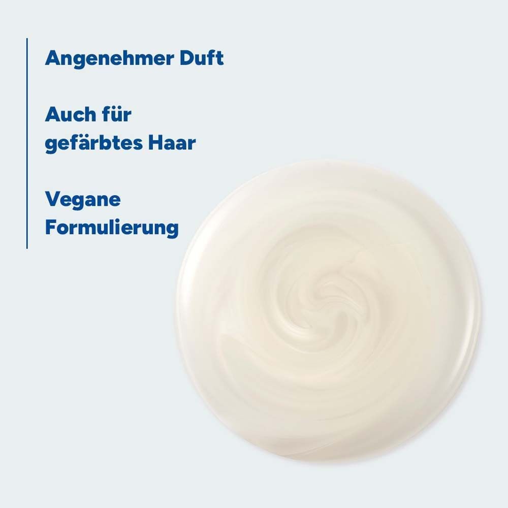 Nahaufnahme einer cremigen Substanz. Text: Angenehmer Duft, Auch für gefärbtes Haar, Vegane Formulierung.