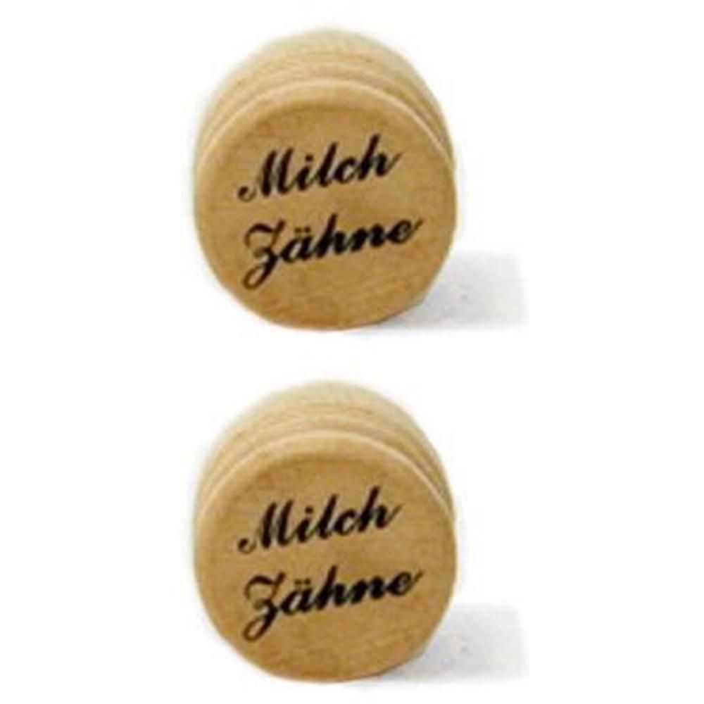 Runde Holzstücke, auf denen "Milch Zähne" steht. Naturfarbenes Holz. Mehrere Stapel.