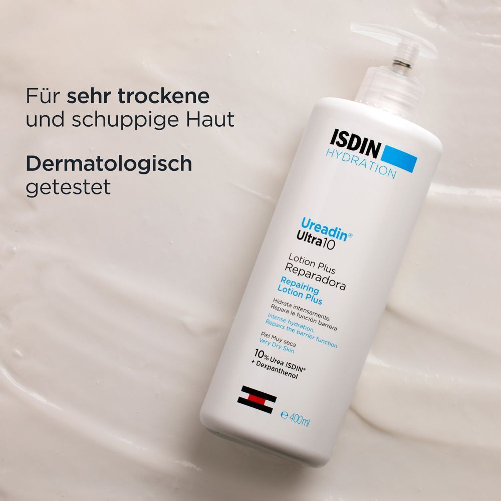 Weiße Flasche ISDIN Ureadin Ultra 10 Lotion Plus auf Creme-Oberfläche. Text: Für sehr trockene und schuppige Haut. Dermatologisch getestet.