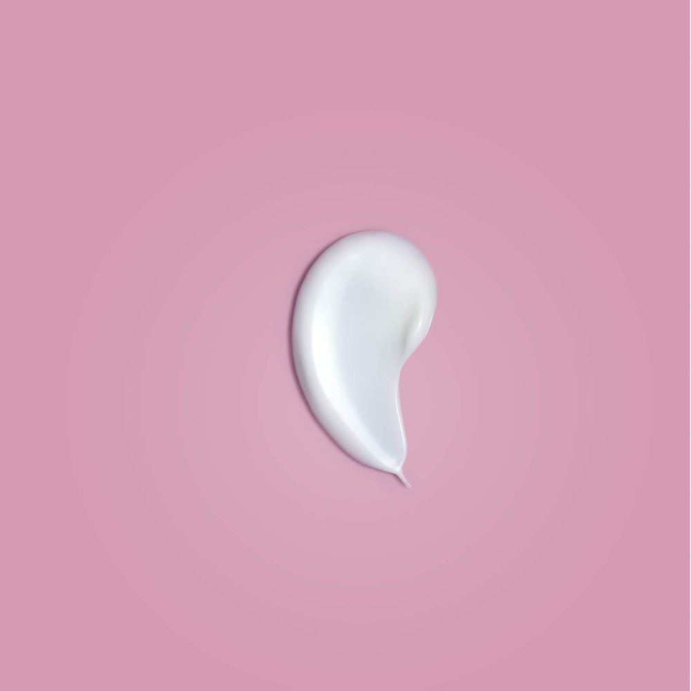 Ein Klecks Creme auf rosa Hintergrund. Weiße Creme mit glatter Oberfläche.