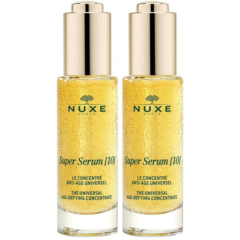 Zwei Flaschen NUXE Super Serum [10]. Goldfarbene Flüssigkeit in Glasflaschen mit goldenen Deckeln. Aufschrift: Super Serum [10].