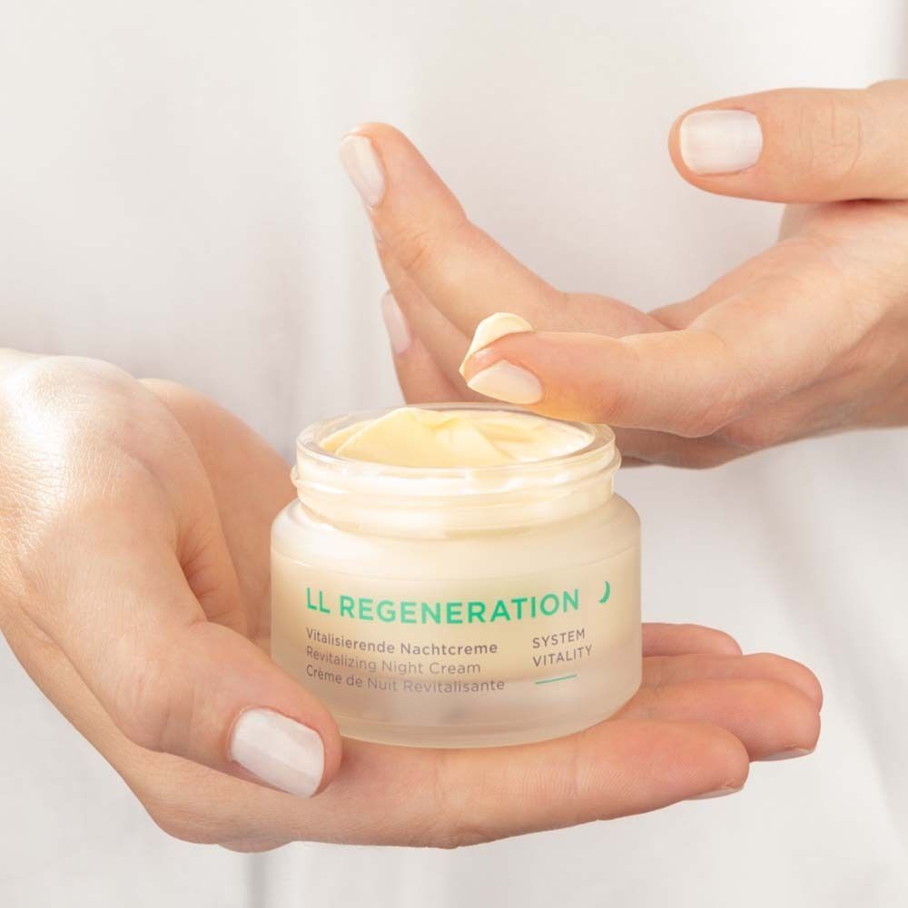Hände öffnen einen Tiegel LL Regeneration Vitalisierende Nachtcreme.