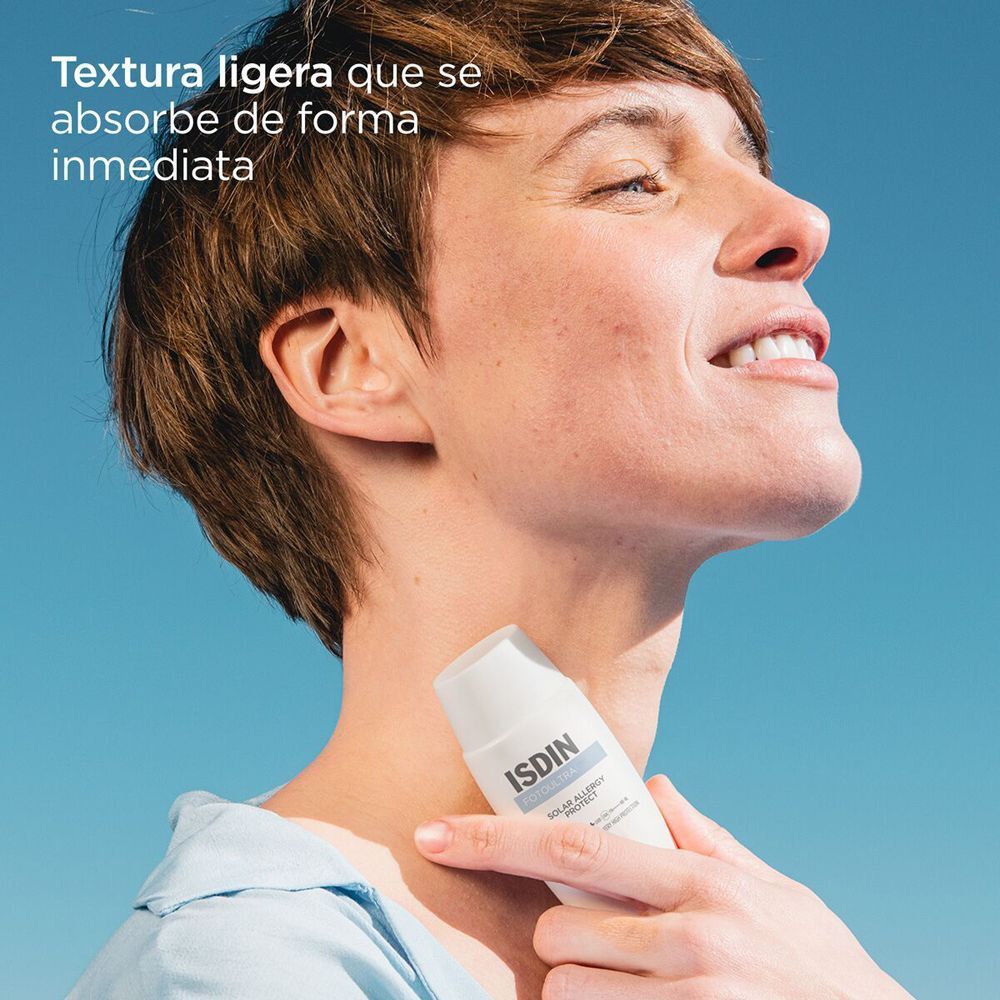 Person hält eine weiße ISDIN FotoUltra Solar Allergy Protect Flasche. Person lächelt. Text: Leichte Textur, zieht sofort ein.