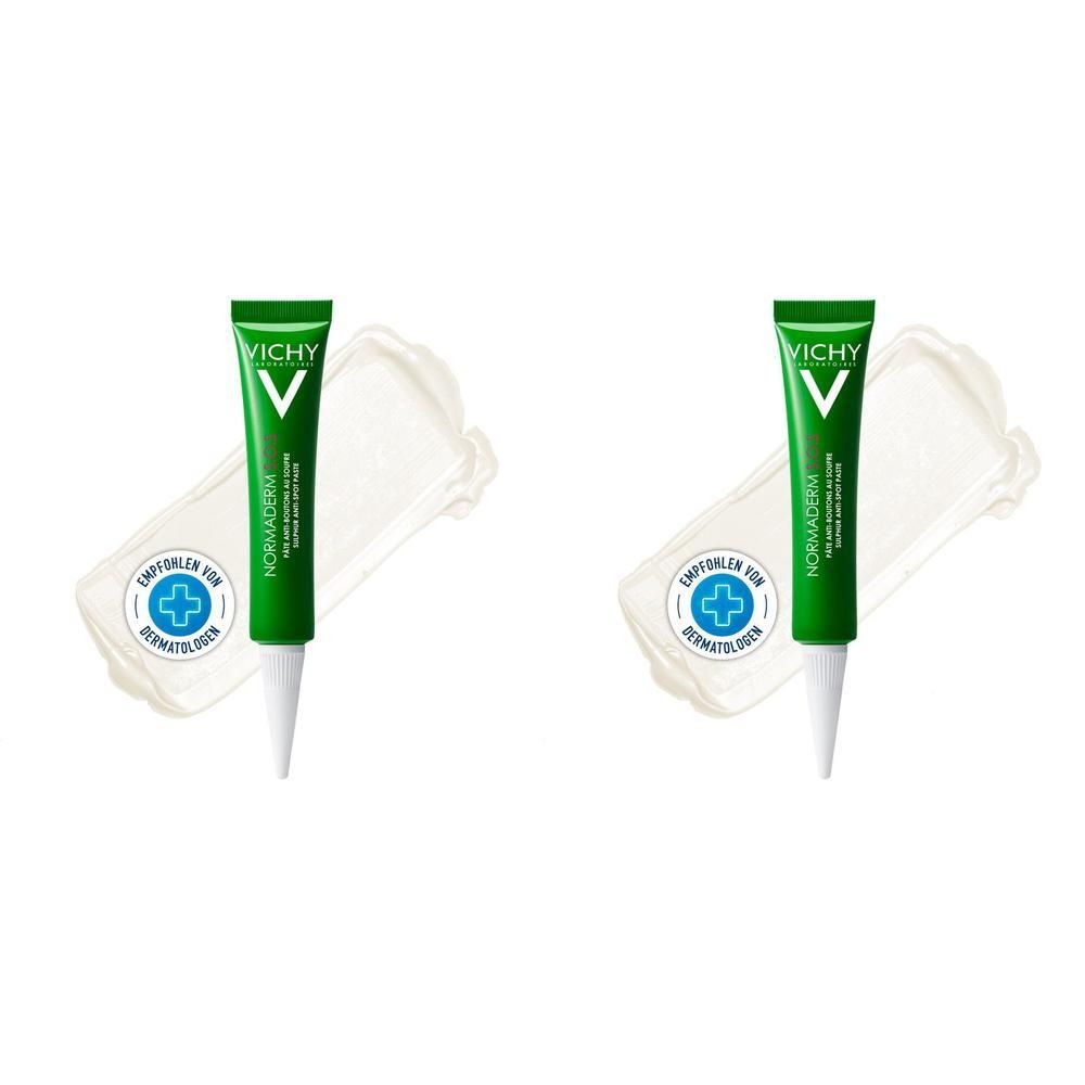 Zwei grüne Tuben mit weißer Spitze und Schriftzug. Auf cremefarbenem Untergrund. Marke VICHY.