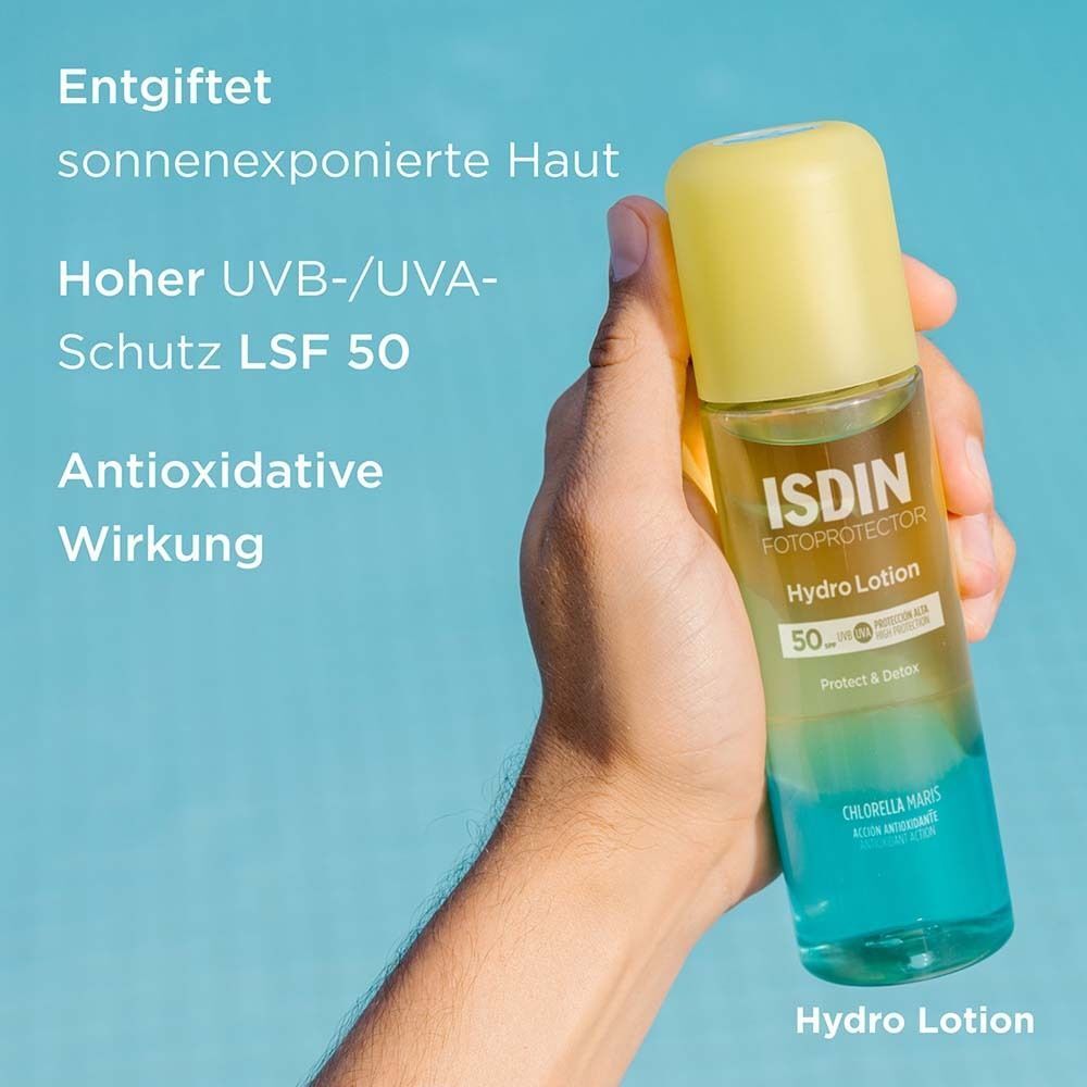 Eine Hand hält eine Flasche mit gelbem Deckel und blau-grünem Boden. Aufschrift: ISDIN Hydro Lotion 50. Text: Entgiftet sonnenexponierte Haut.
