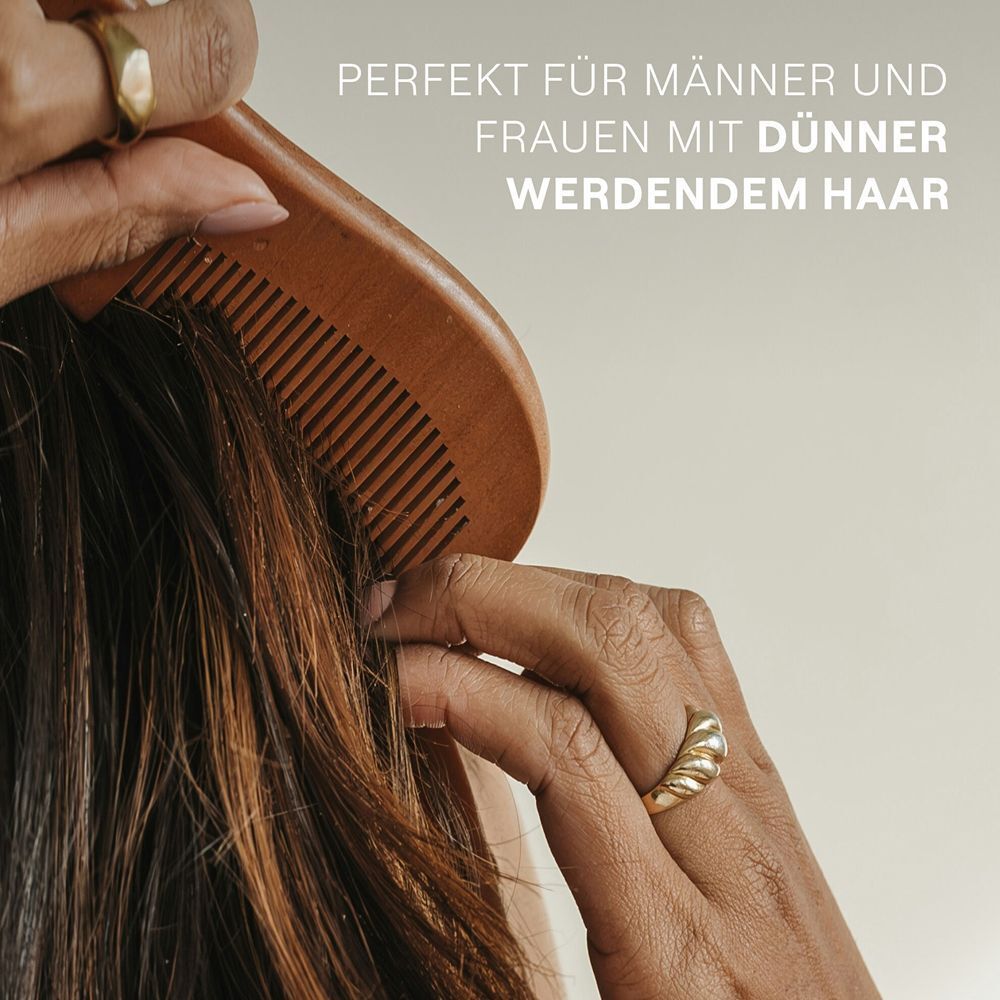 Nahaufnahme einer Hand, die einen Holzkamm durch das Haar zieht. Text: Perfekt für Männer und Frauen mit dünner werdendem Haar.