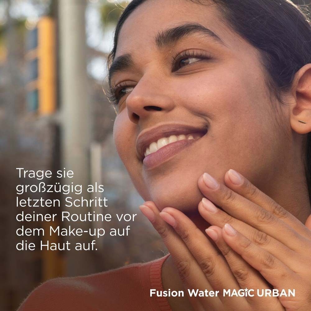 Eine Frau trägt das Produkt auf. Text: Trage sie großzügig als letzten Schritt deiner Routine vor dem Make-up auf die Haut auf.