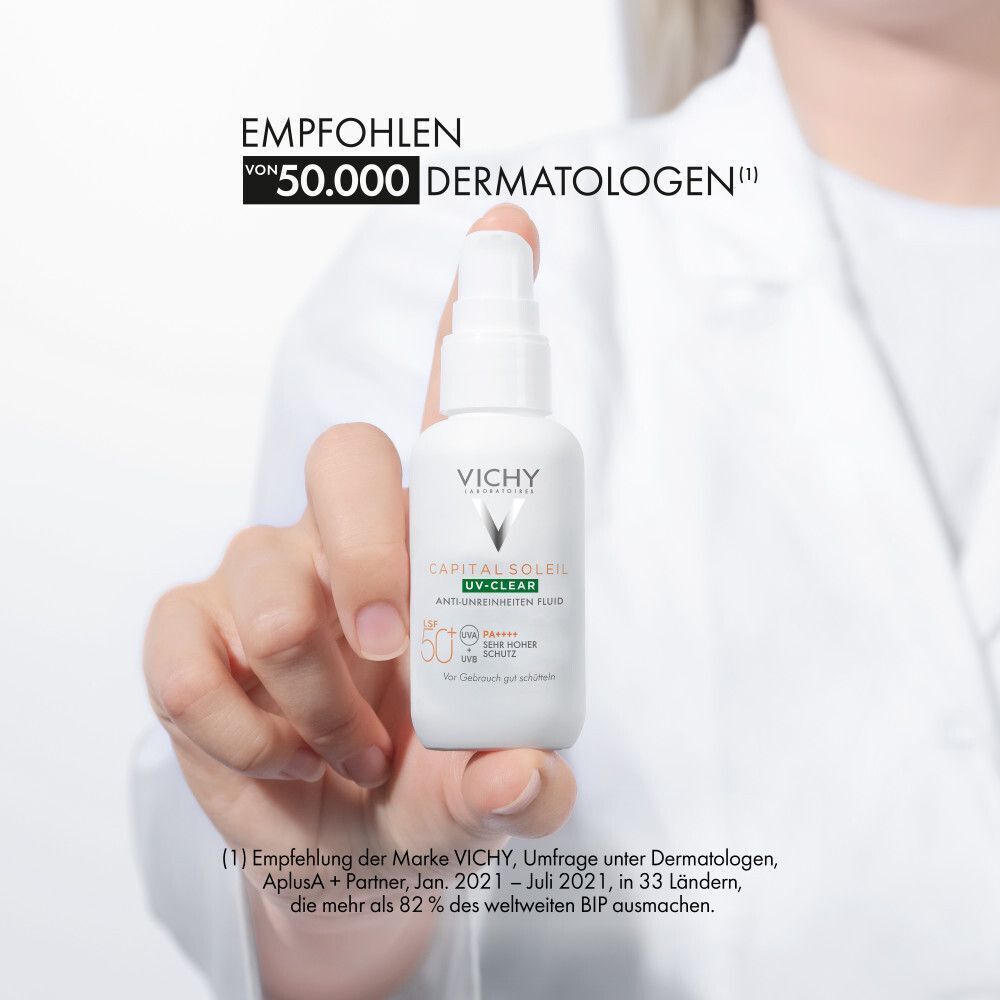 Hand hält eine weiße Flasche. Aufschrift: Vichy Capital Soleil UV-Clear. Empfohlen von 50.000 Dermatologen.