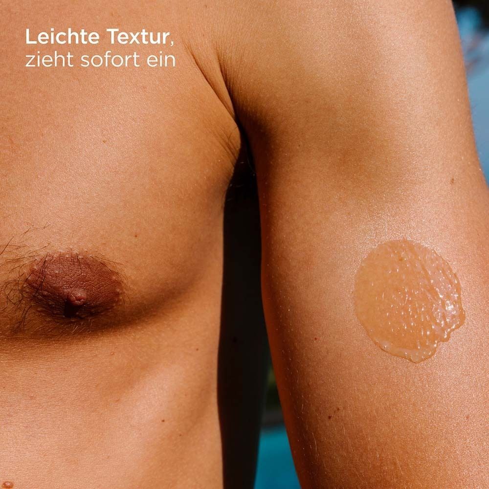 Nahaufnahme eines Arms mit aufgetragener Flüssigkeit. Text: Leichte Textur, zieht sofort ein.
