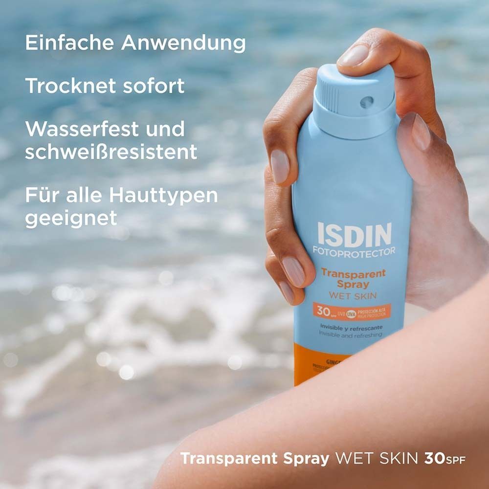 Person hält eine blaue Sprühflasche. Aufschrift: ISDIN Fotoprotector Transparent Spray Wet Skin 30. Text: Einfache Anwendung, trocknet sofort.