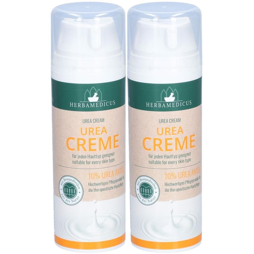 Zwei Cremes mit weißem Spender und transparentem Deckel. Aufschrift: UREA CREME, 10% UREA. Marke: HERBAMEDICUS.
