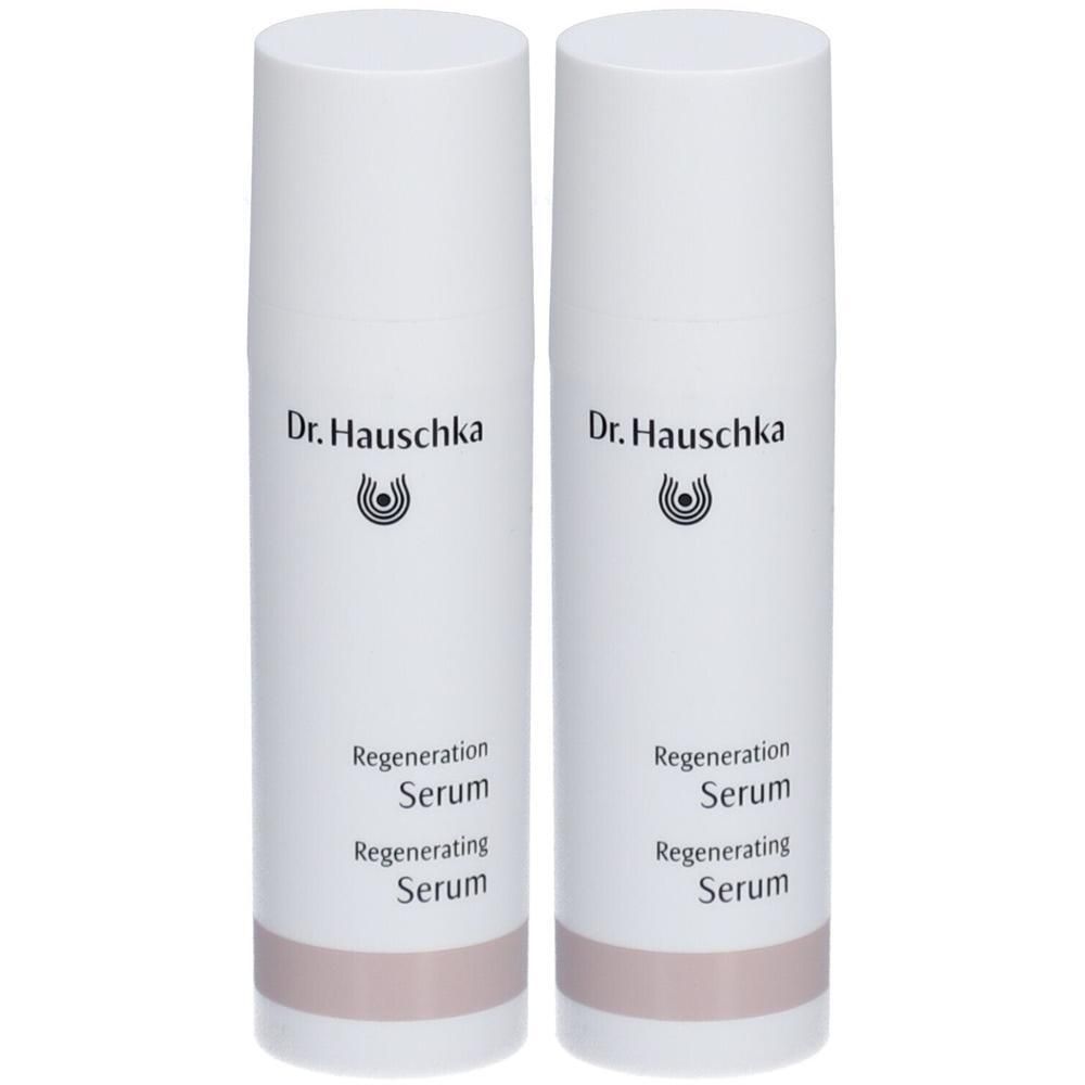 Zwei weiße Flaschen mit Aufschrift "Dr. Hauschka" und "Regeneration Serum". Unterer Teil der Flaschen ist rosa.