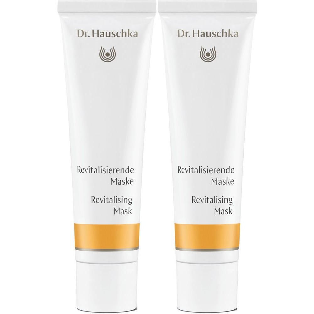 Zwei weiße Tuben Dr. Hauschka Revitalisierende Maske mit orange-goldfarbenem Band.