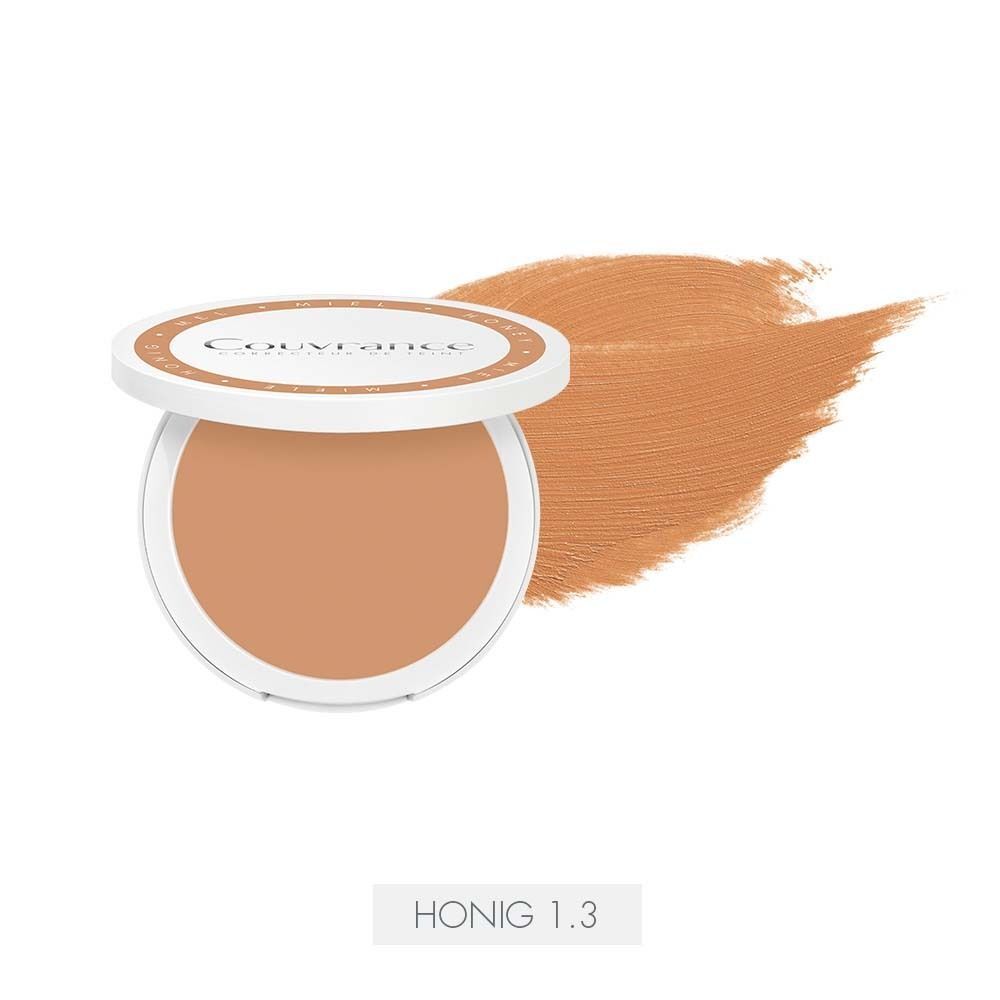 Kompaktes Creme-Make-up mit geöffnetem Deckel. Daneben ein Farbfleck. Auf dem Boden steht Honig 1.3.