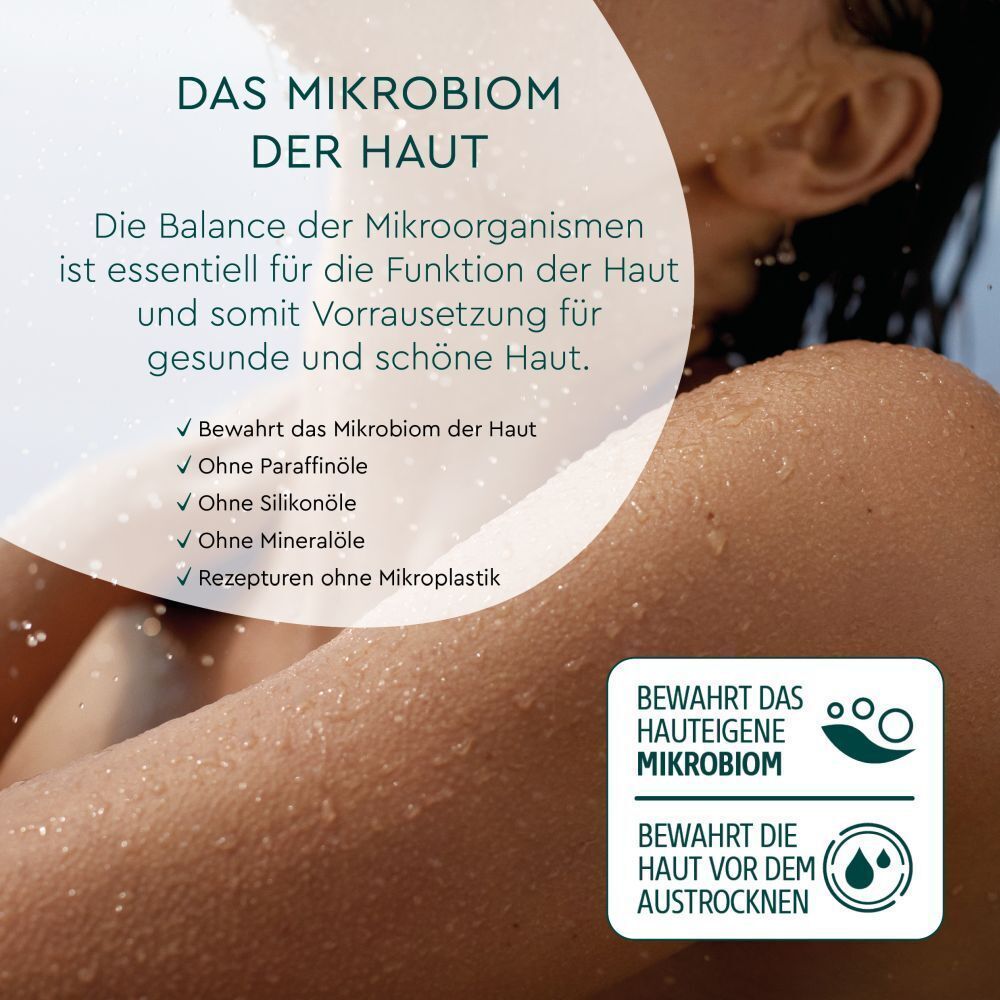 Text über das Mikrobiom der Haut. Frau berührt ihre Schulter. Text: Bewahrt das hauteigene Mikrobiom.