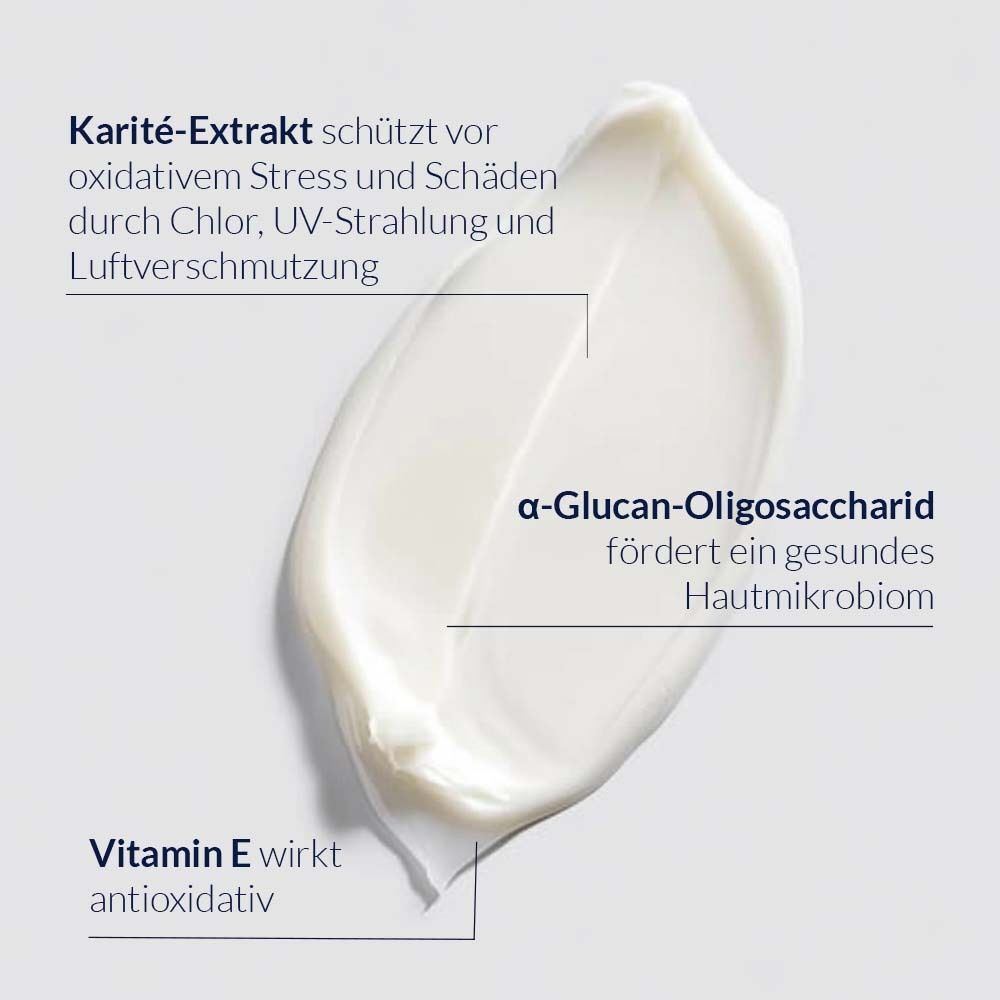 Nahaufnahme einer Creme. Text: Karité-Extrakt schützt vor oxidativem Stress. α-Glucan-Oligosaccharid fördert ein gesundes Hautmikrobiom. Vitamin E wirkt antioxidativ.