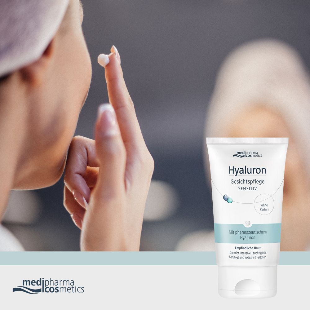 Frau trägt Creme auf das Gesicht auf. Daneben eine Tube HYALURON GESICHTSPFLEGE sensitive Creme. Weiße Tube mit blauer Schrift.