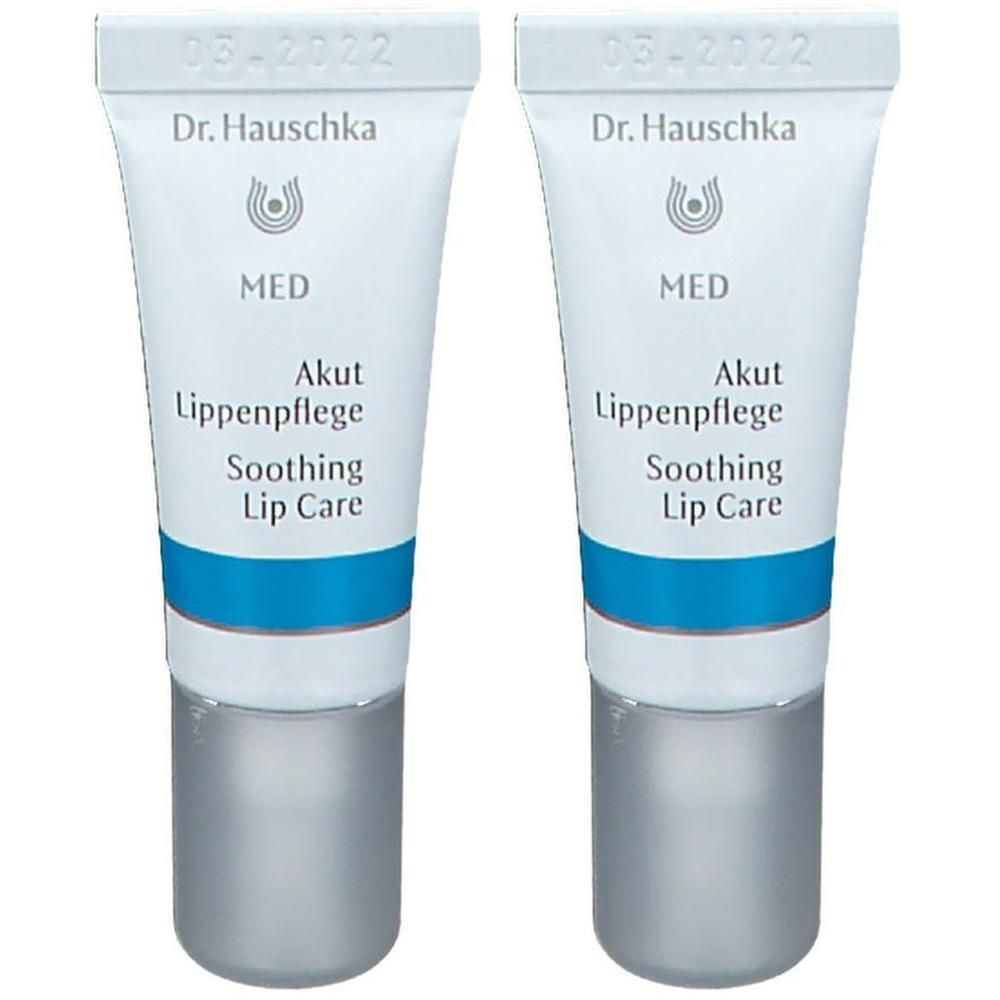 Zwei Tuben Lippenpflege. Weiß, mit blauem Streifen und silberfarbenem Verschluss. Aufschrift: Dr. Hauschka MED Akut Lippenpflege Soothing Lip Care.