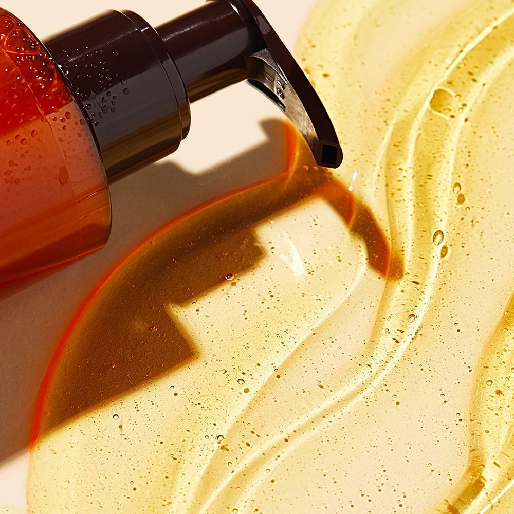 Nahaufnahme einer Pumpe und Gel. Gelbliche Flüssigkeit mit Bläschen. Braune Pumpe.