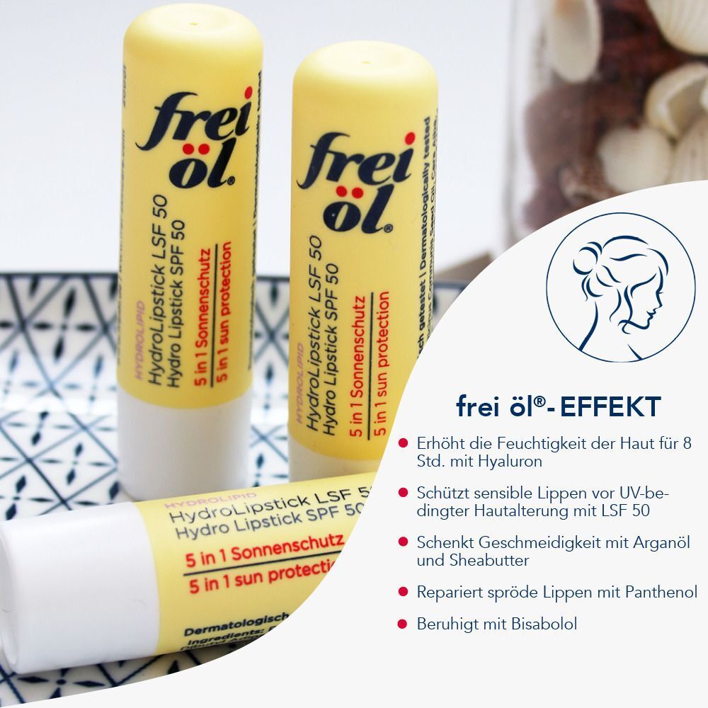 Drei FREI ÖL Hydrolipid HydroLipstick LSF 50. Gelbe Lippenpflegestifte mit Produktinformationen. Auf Tisch.